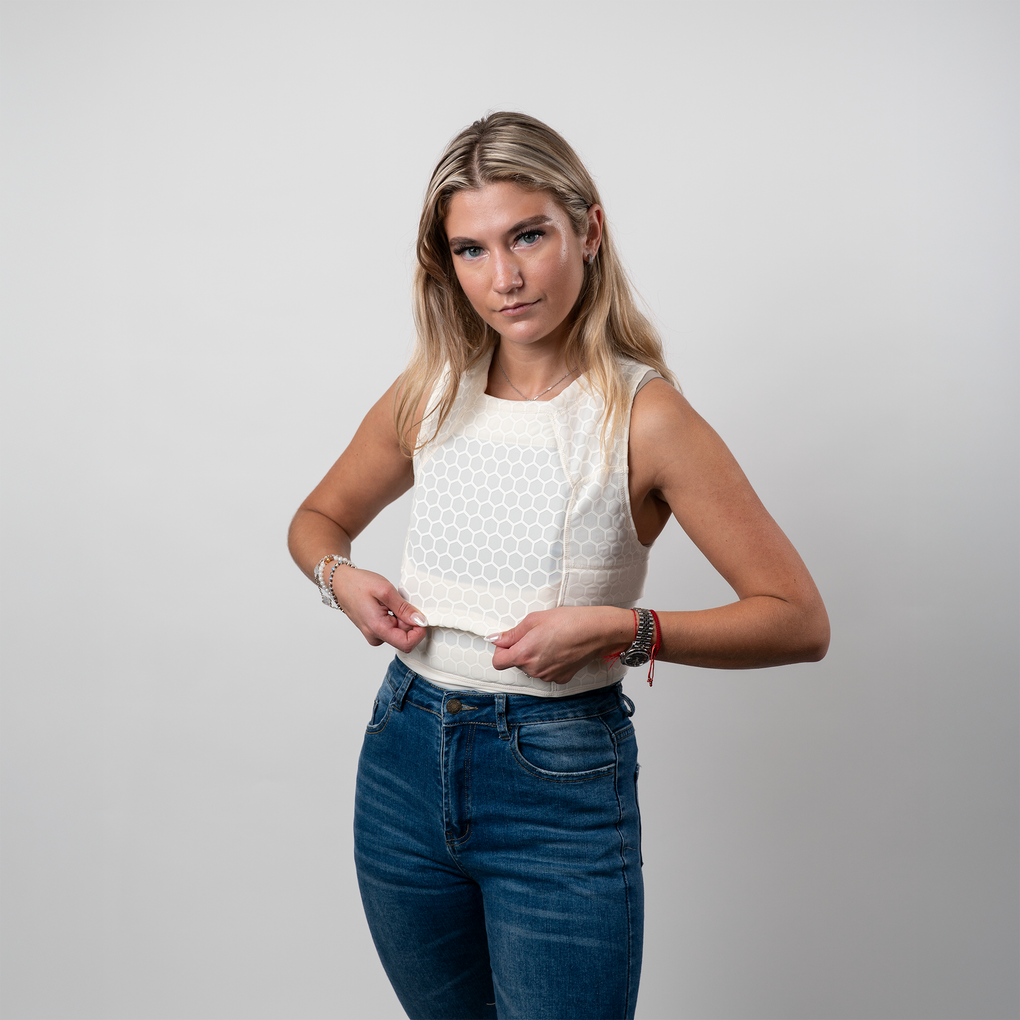 A woman wearing a sleeveless white compression shirt for protection