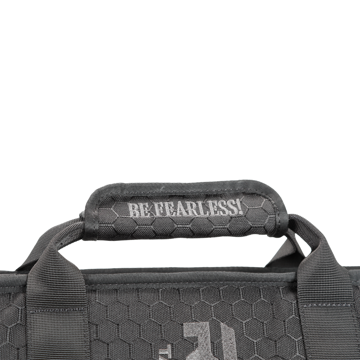 Close-up of a black shield carrier bag handle with a hexagonal texture, featuring the white text "BE FEARLESS!"