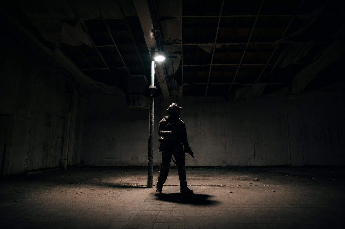 A mean wearing tactical gear standing under a street light at night