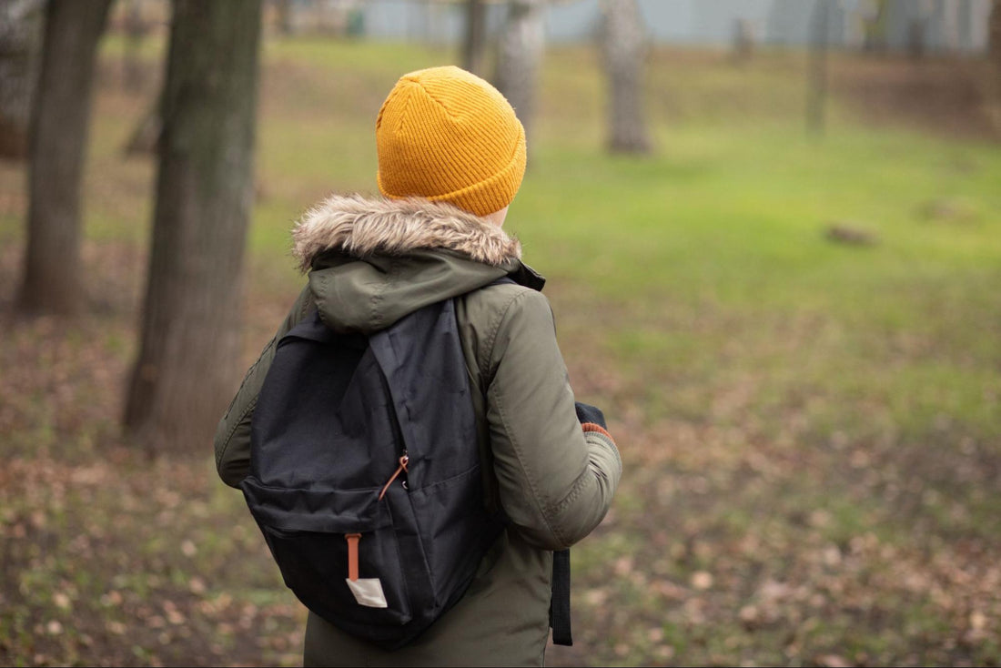 A child wearing a black backpack containing a ballistic insert
