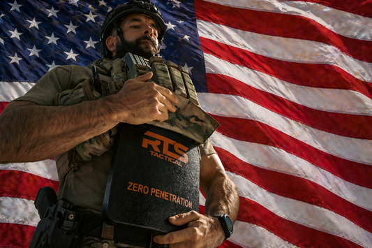 A man putting his ballistic plate into his plate carrier with an American flag behind him
