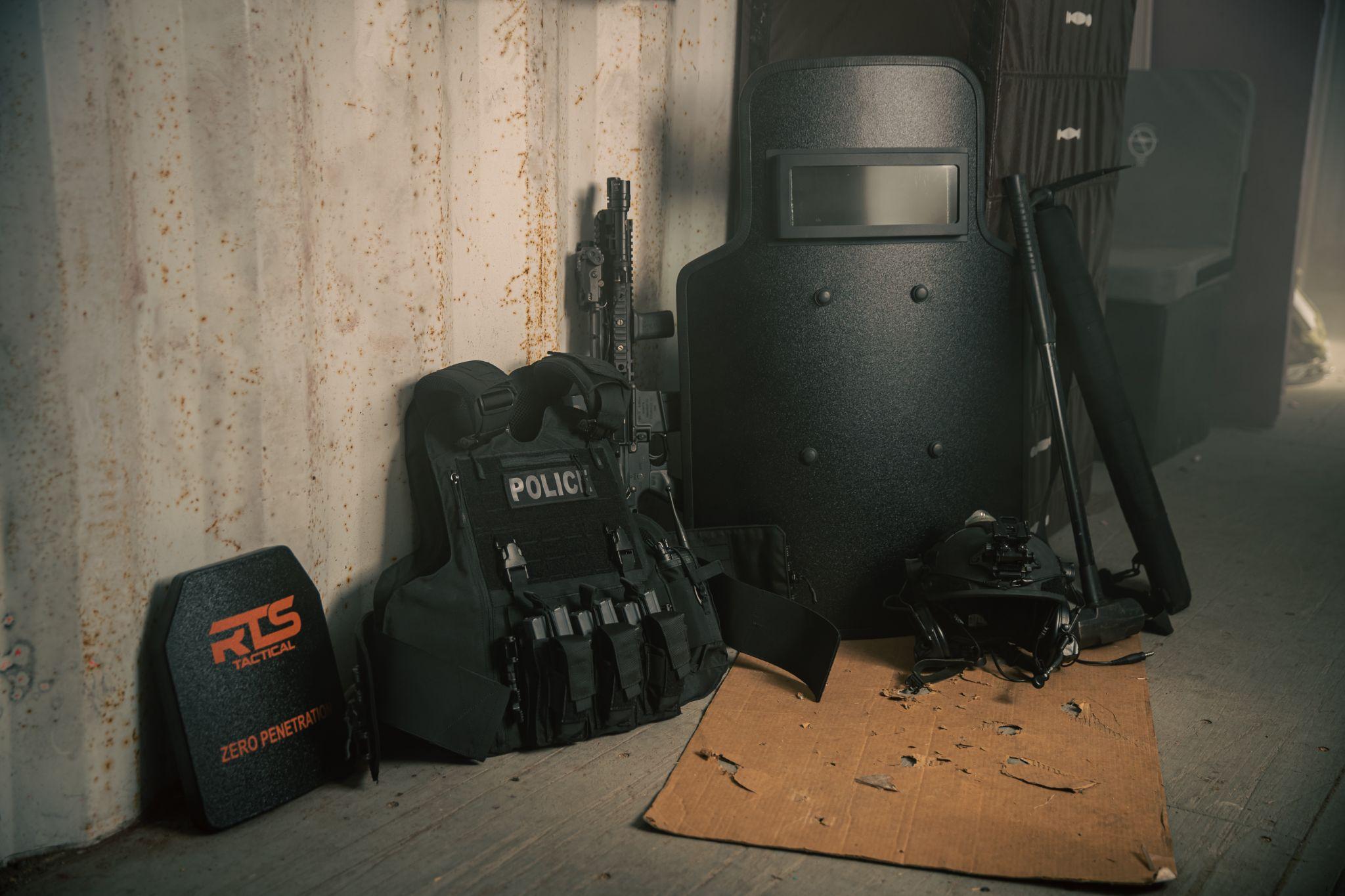 Tactical gear includes a ballistic vest labeled 