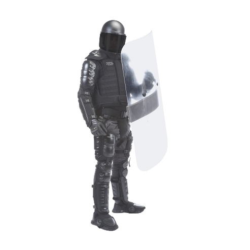 A person in full black riot gear stands holding a large clear shield. The gear includes a helmet and padded armor.