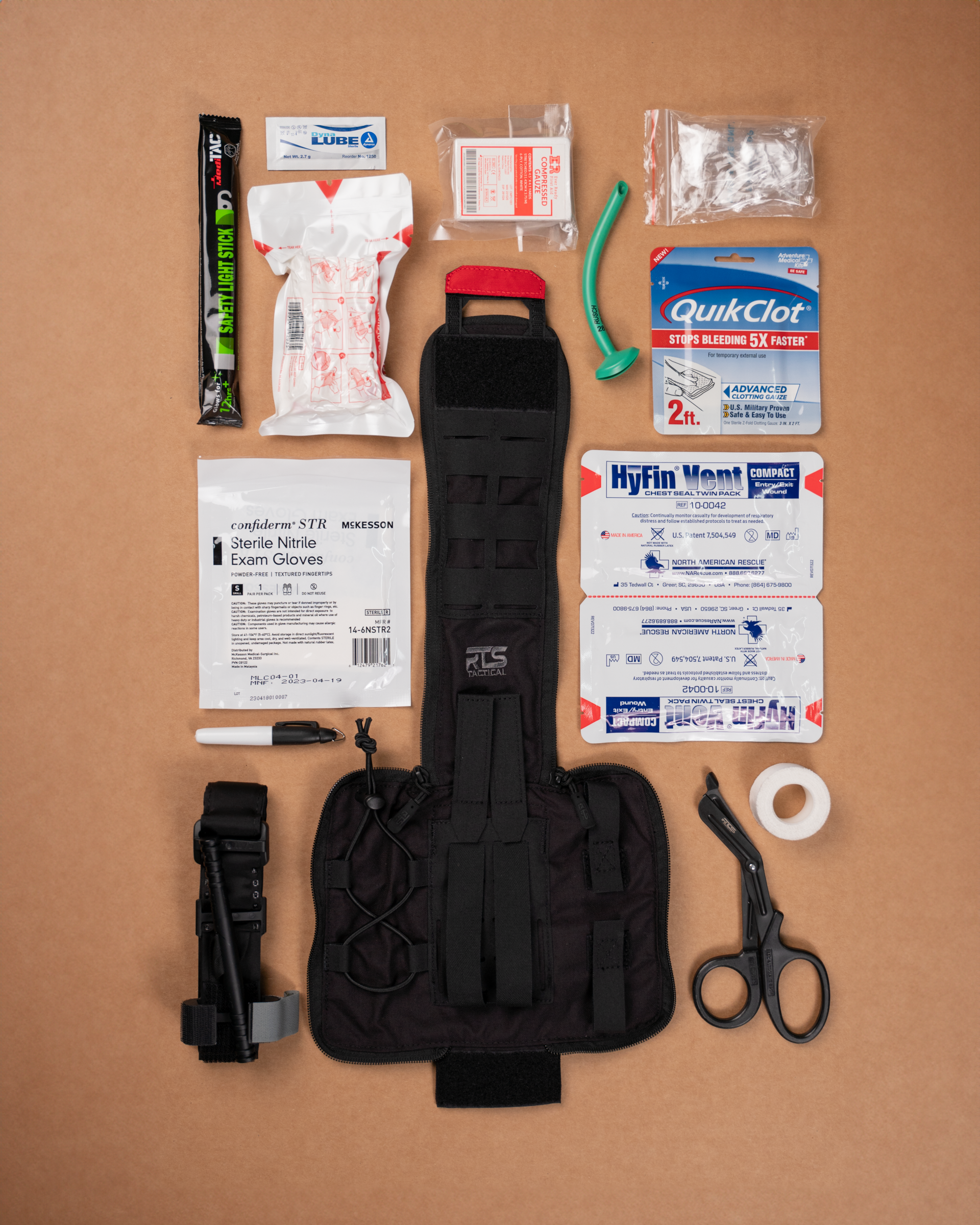 An IFAK med kit with the contents of the bag displayed on a table.