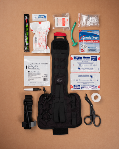 An IFAK med kit with the contents of the bag displayed on a table.