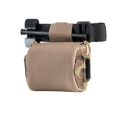 Compact medical pouch with a tan fabric cover, holding a black tourniquet. The pouch features camouflage accents, creating a tactical and practical appearance.
