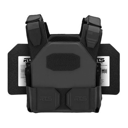 A black tactical vest with padded shoulders and attached plates rests flat against a plain background.