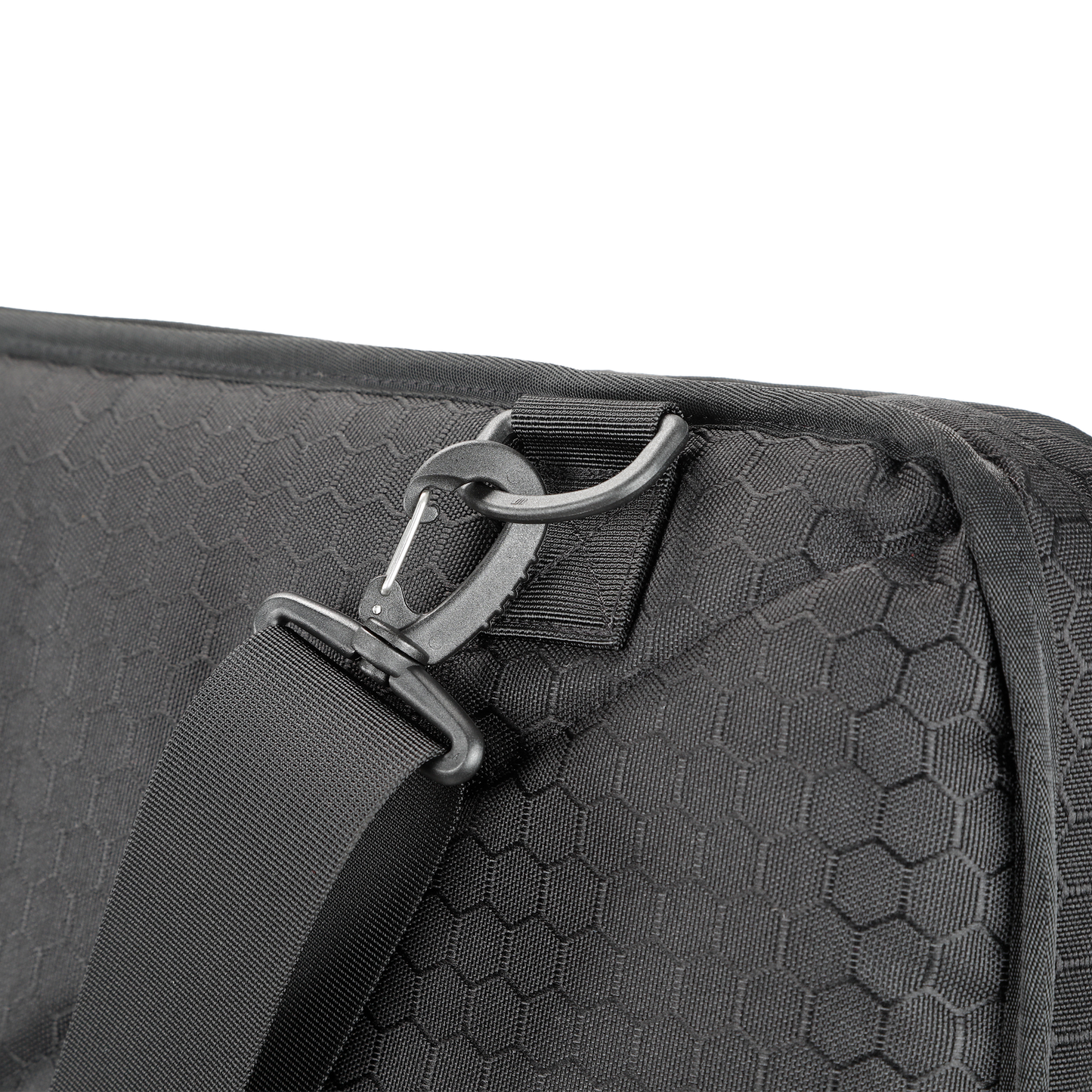 Close-up of a black hexagon-patterned tactical shield bag with a durable strap and metal hook. The design conveys sturdiness and modern utility.