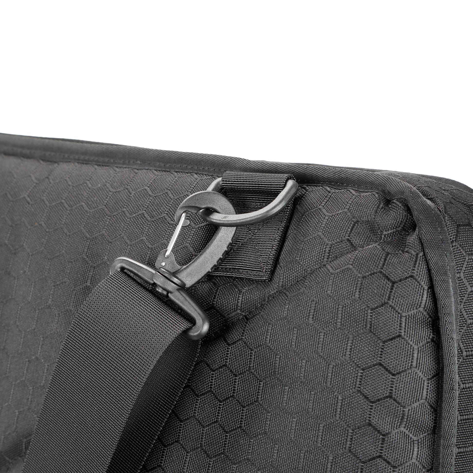 Close-up of a black hexagon-patterned tactical shield bag with a durable strap and metal hook. The design conveys sturdiness and modern utility.