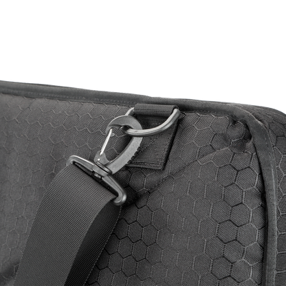 Close-up of a black hexagon-patterned tactical shield bag with a durable strap and metal hook. The design conveys sturdiness and modern utility.