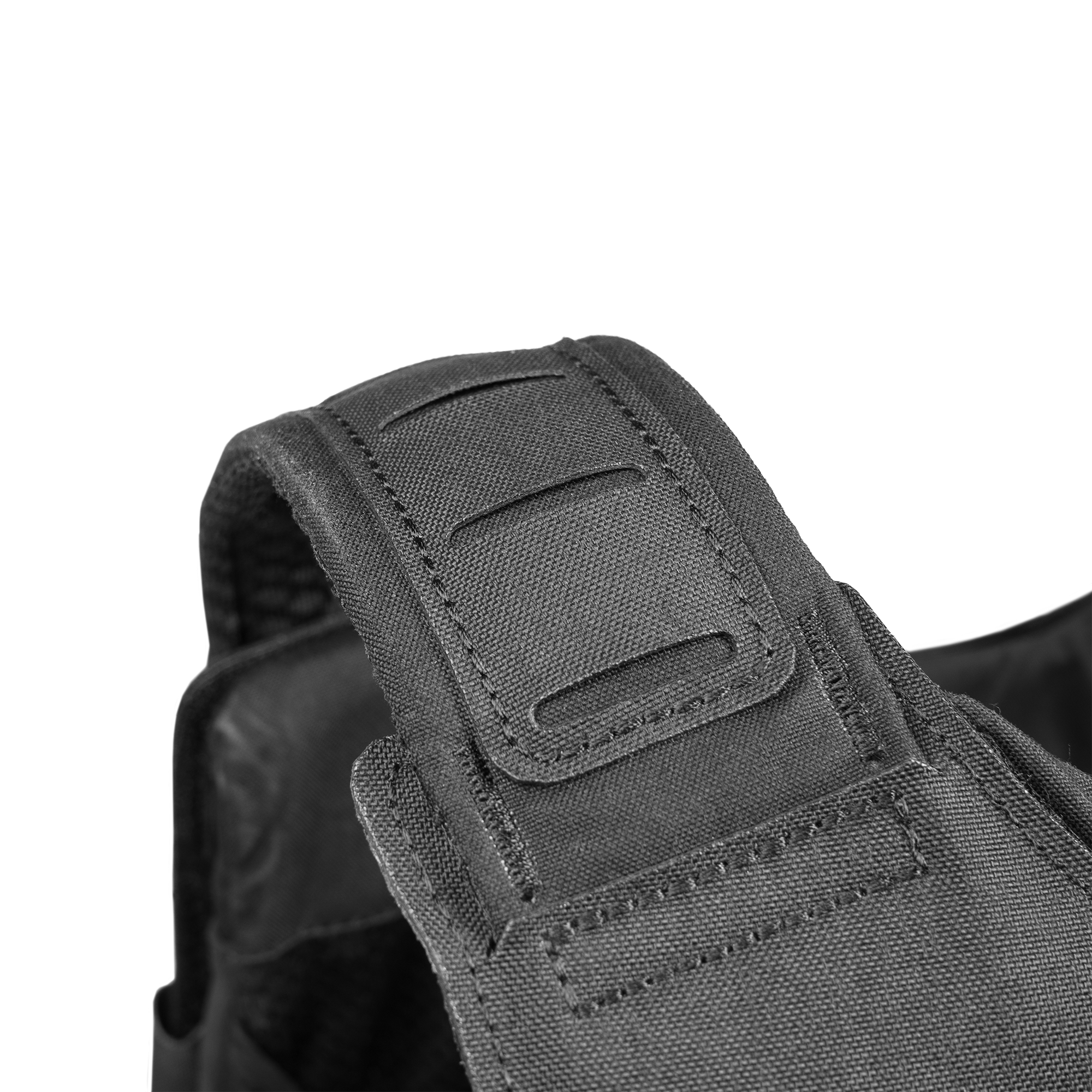 Close-up view of a durable, black tactical vest strap featuring reinforced stitching and adjustable hook-and-loop fasteners.