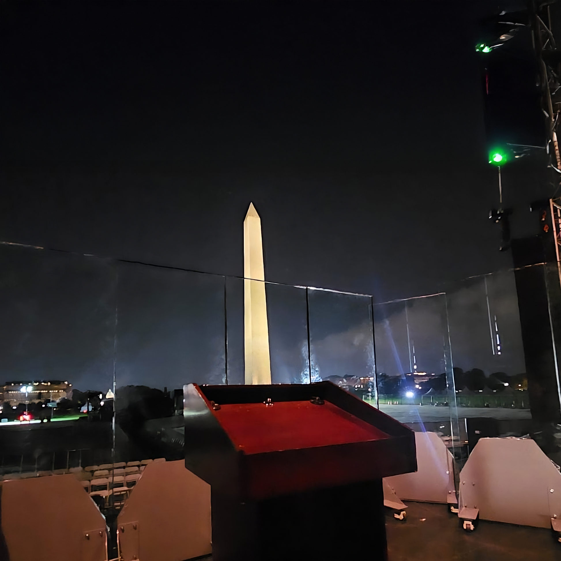 A podium surrounded by bulletproof glass in front of the Washington Monument.