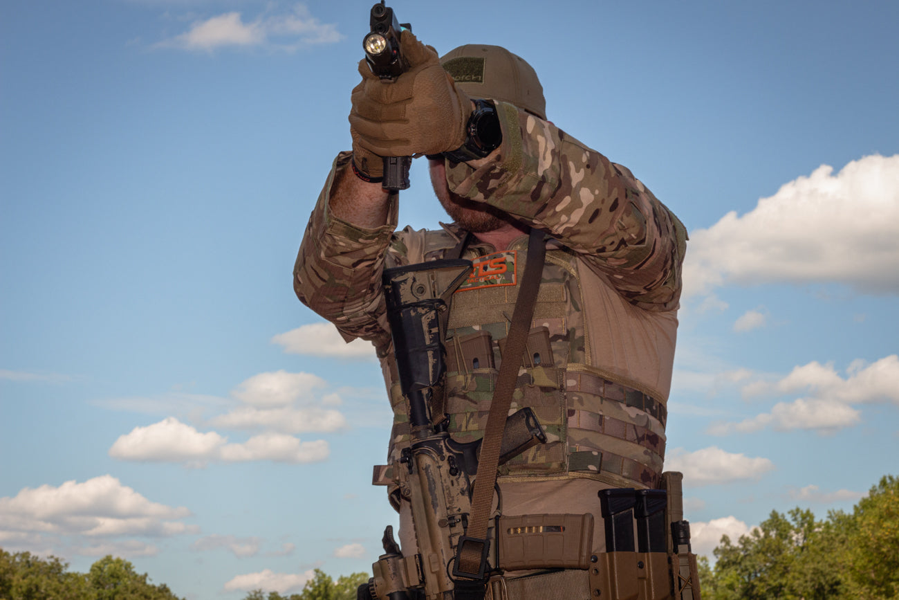 A man in tactical gear wearing the Multicam RTS Tactical plate carrier and ceramic armor plates.
