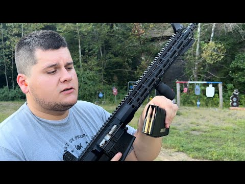 A person holding a semi-automatic rifle, preparing to load a magazine